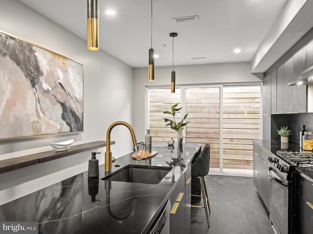 kitchen featuring backsplash, dark tile patterned floors, stainless steel appliances, sink, and decorative light fixtures