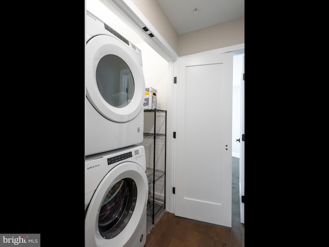 washroom featuring dark wood-type flooring and stacked washer and dryer