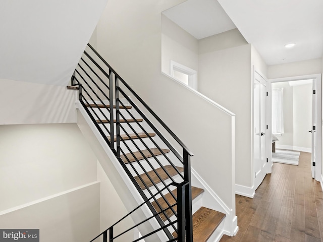 staircase with hardwood / wood-style floors