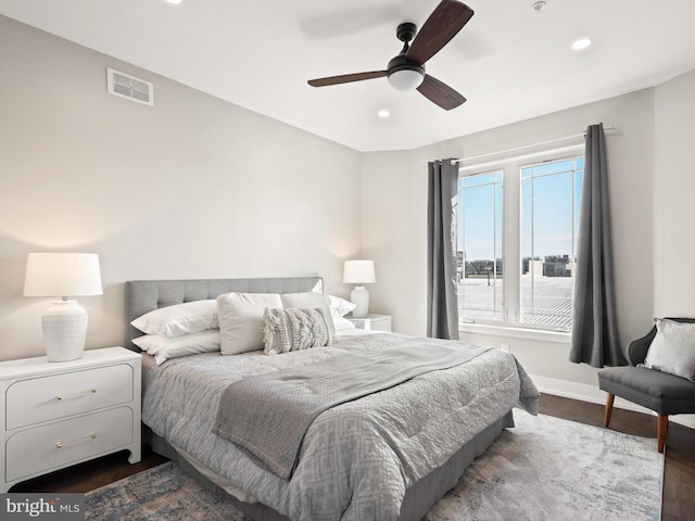 bedroom with dark hardwood / wood-style flooring and ceiling fan