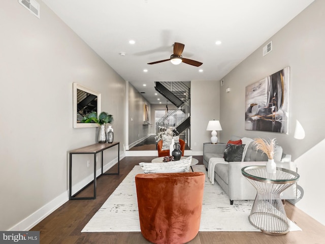 living room featuring ceiling fan and dark hardwood / wood-style flooring