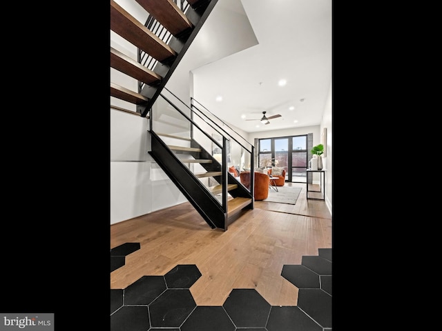 staircase featuring hardwood / wood-style flooring and ceiling fan