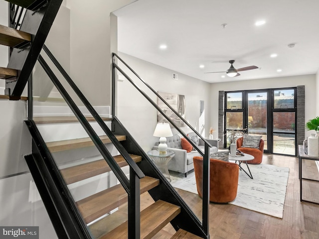 stairway featuring french doors, wood-type flooring, and ceiling fan