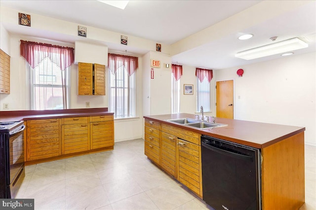 kitchen with a center island with sink, sink, black appliances, and a healthy amount of sunlight