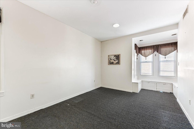 empty room with dark colored carpet