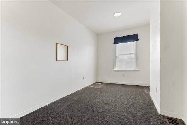 empty room with dark colored carpet