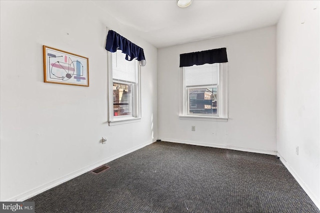 empty room featuring dark carpet