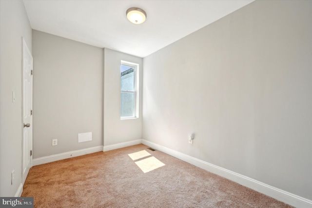 unfurnished room featuring light carpet