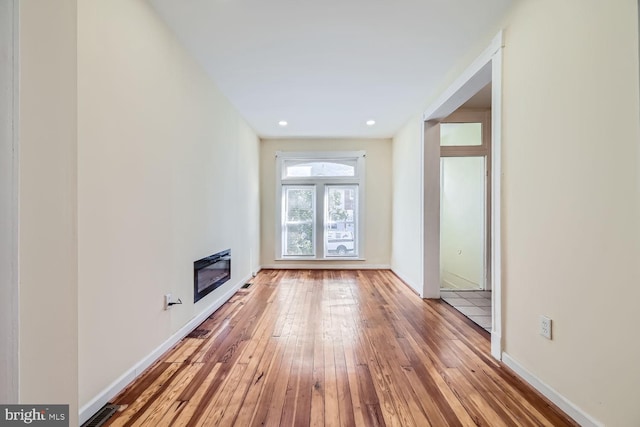 unfurnished living room featuring light wood-type flooring and heating unit