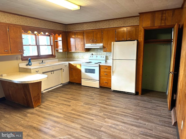 kitchen featuring ornamental molding, wood-type flooring, backsplash, and white appliances