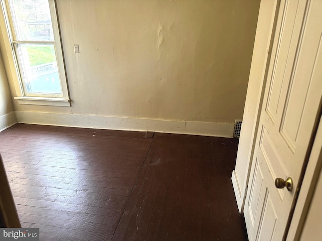 unfurnished room with dark hardwood / wood-style flooring