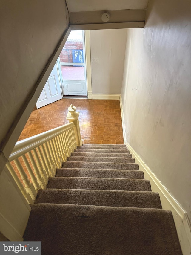 stairs featuring parquet floors