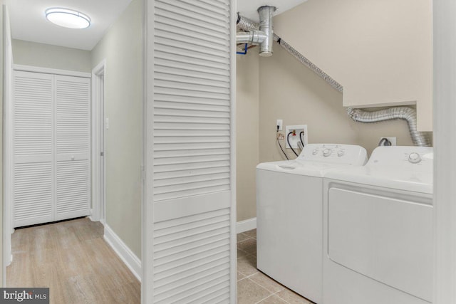 clothes washing area featuring light hardwood / wood-style flooring and washing machine and clothes dryer