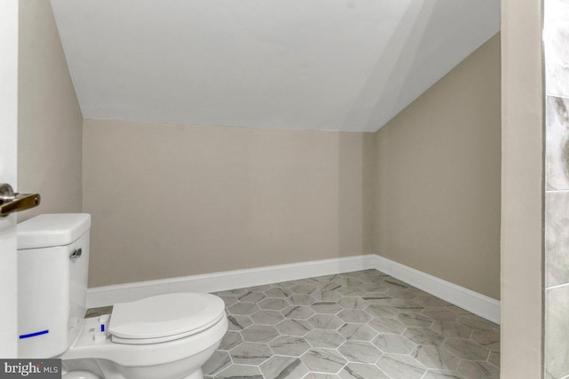 bathroom with vaulted ceiling and toilet