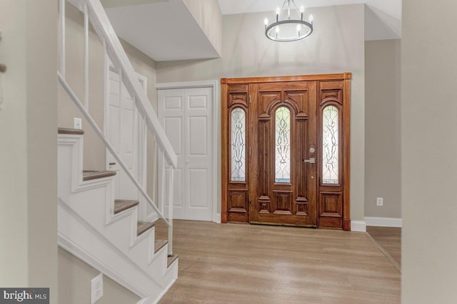 entryway with light hardwood / wood-style flooring and a notable chandelier