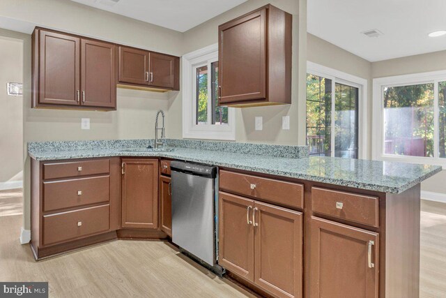 kitchen featuring dishwasher, a healthy amount of sunlight, sink, and light wood-type flooring