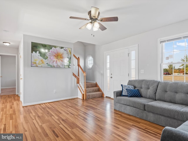 living room with light hardwood / wood-style floors and ceiling fan