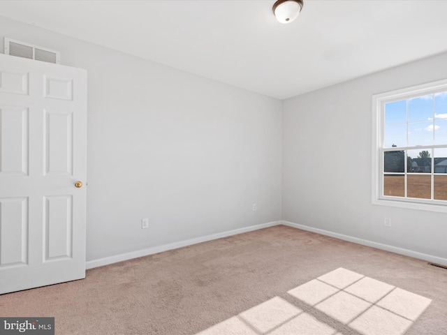 spare room featuring light carpet