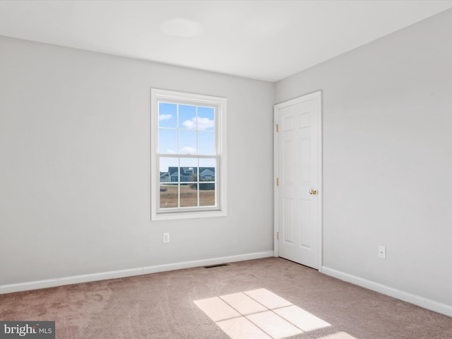 unfurnished room featuring light colored carpet