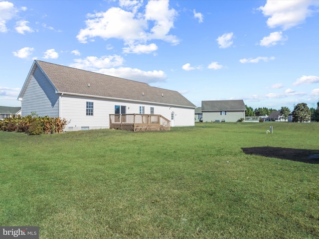 back of property with a deck and a lawn