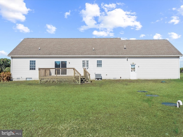 rear view of property featuring a deck, a lawn, and central AC unit