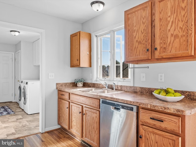 kitchen featuring independent washer and dryer, light wood-type flooring, sink, and stainless steel dishwasher