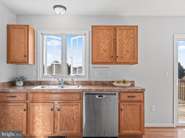 kitchen with light hardwood / wood-style flooring, stainless steel dishwasher, and sink