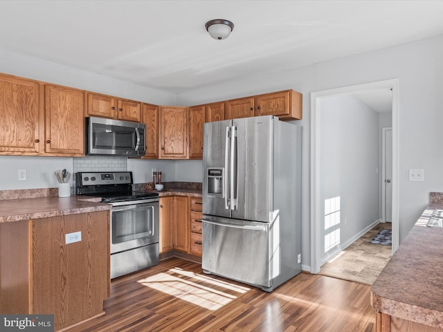 kitchen featuring decorative backsplash, stainless steel appliances, and dark hardwood / wood-style flooring