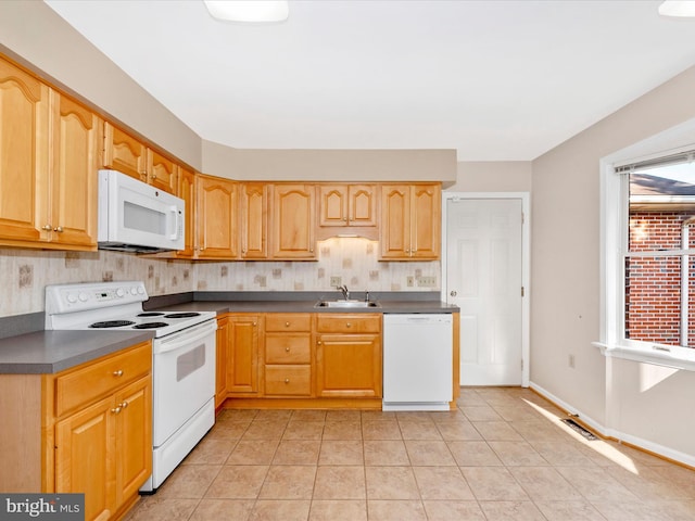 kitchen with white appliances, light tile patterned floors, and sink