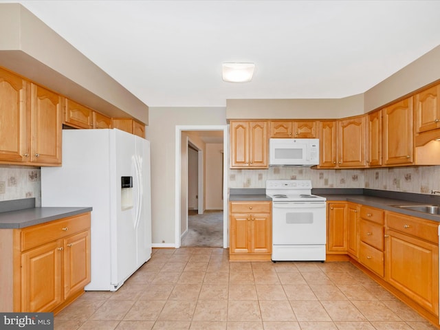 kitchen with white appliances, light tile patterned floors, and sink