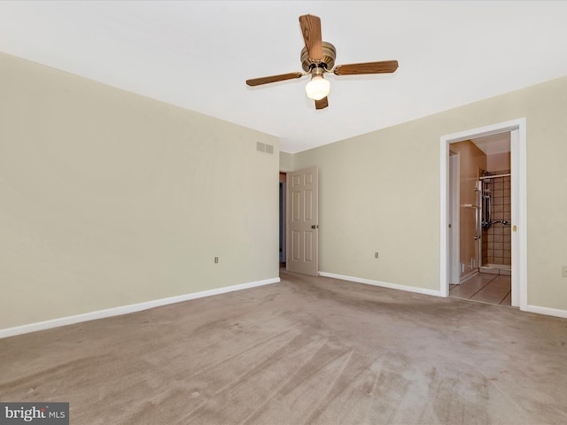 unfurnished bedroom with light carpet, ensuite bathroom, and ceiling fan