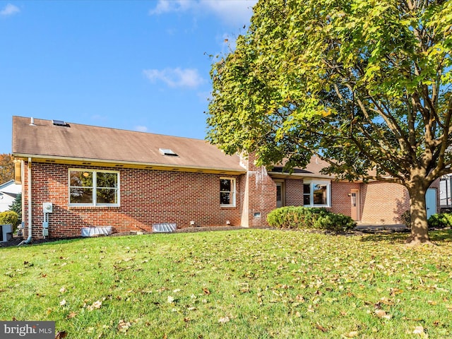 rear view of property with a lawn