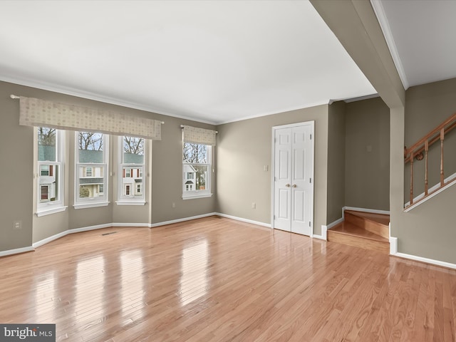 spare room featuring crown molding and light hardwood / wood-style floors