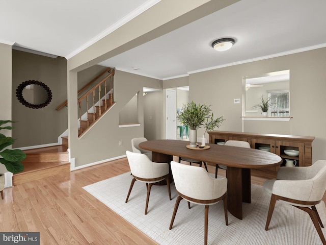 dining area with light wood-type flooring and ornamental molding