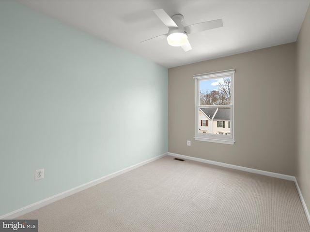 carpeted spare room featuring ceiling fan