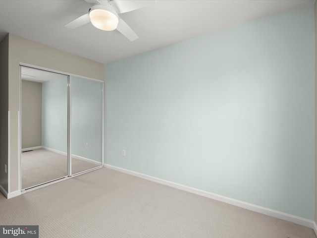 unfurnished bedroom featuring light colored carpet, a closet, and ceiling fan