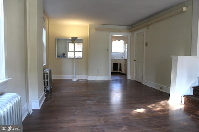 unfurnished living room featuring dark hardwood / wood-style flooring and radiator