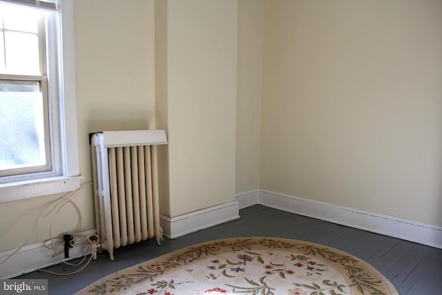 unfurnished room featuring radiator heating unit