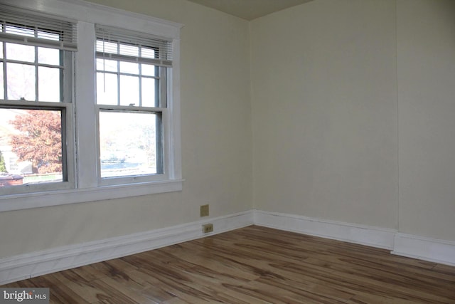 empty room with a healthy amount of sunlight and hardwood / wood-style flooring