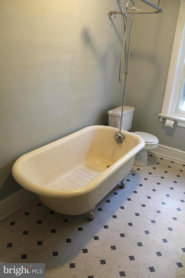 bathroom featuring a tub to relax in and toilet