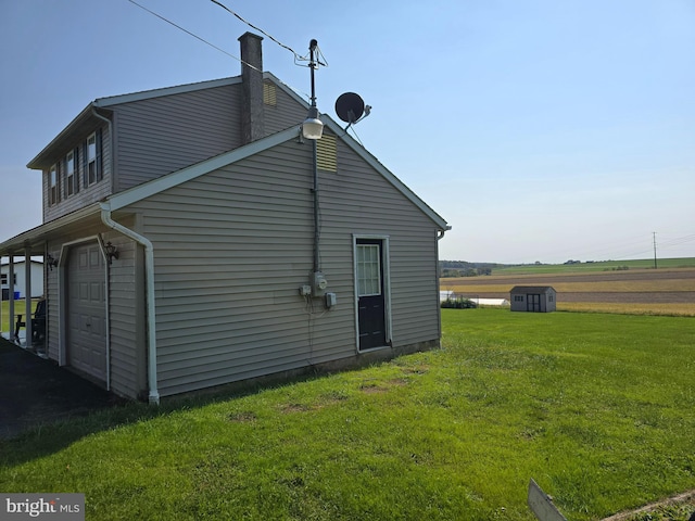 view of side of home with a yard and a rural view