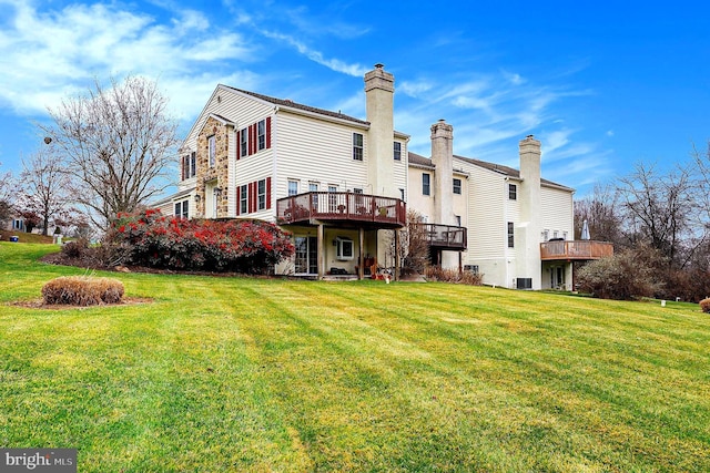 rear view of house with a lawn, a wooden deck, and central AC unit