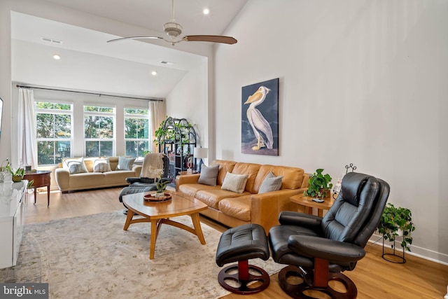 living room featuring light hardwood / wood-style floors, high vaulted ceiling, and ceiling fan