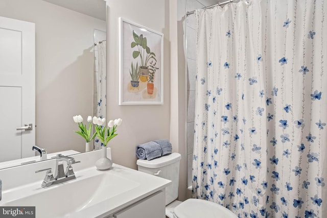 bathroom featuring vanity, curtained shower, and toilet