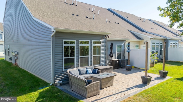 rear view of house with a yard, an outdoor living space with a fire pit, and a patio area