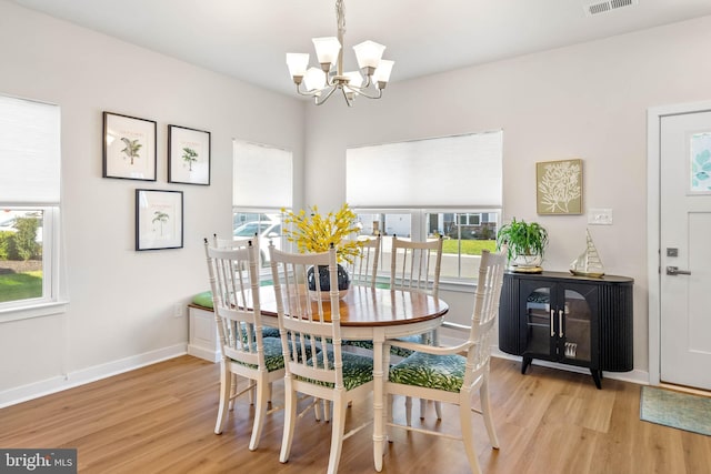 dining space featuring a notable chandelier, plenty of natural light, and light hardwood / wood-style floors