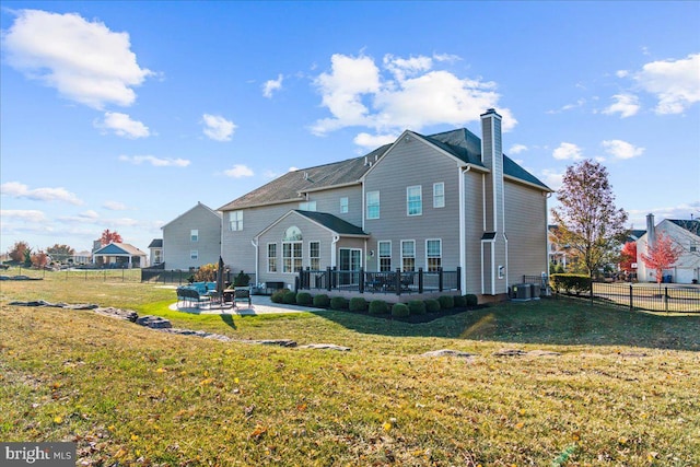 back of property with a patio area, a yard, and central air condition unit