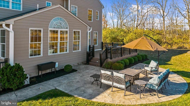 rear view of house featuring a wooden deck, a patio, and an outdoor hangout area