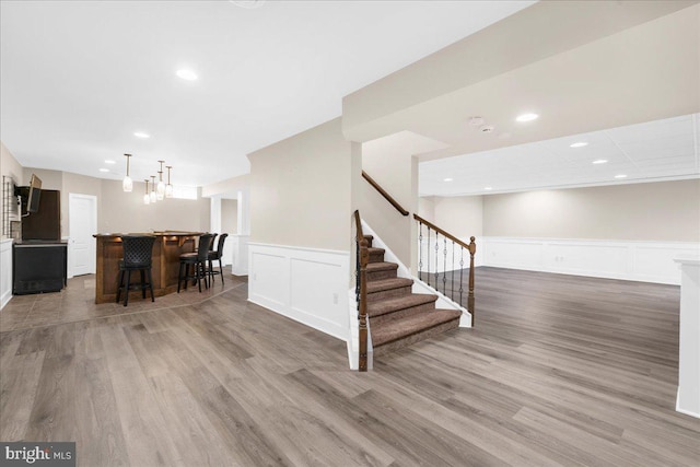 interior space with bar area and hardwood / wood-style flooring