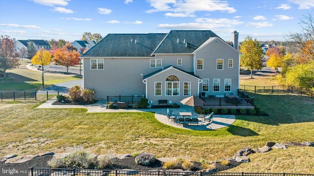 back of house with a lawn, an outdoor living space, and a patio